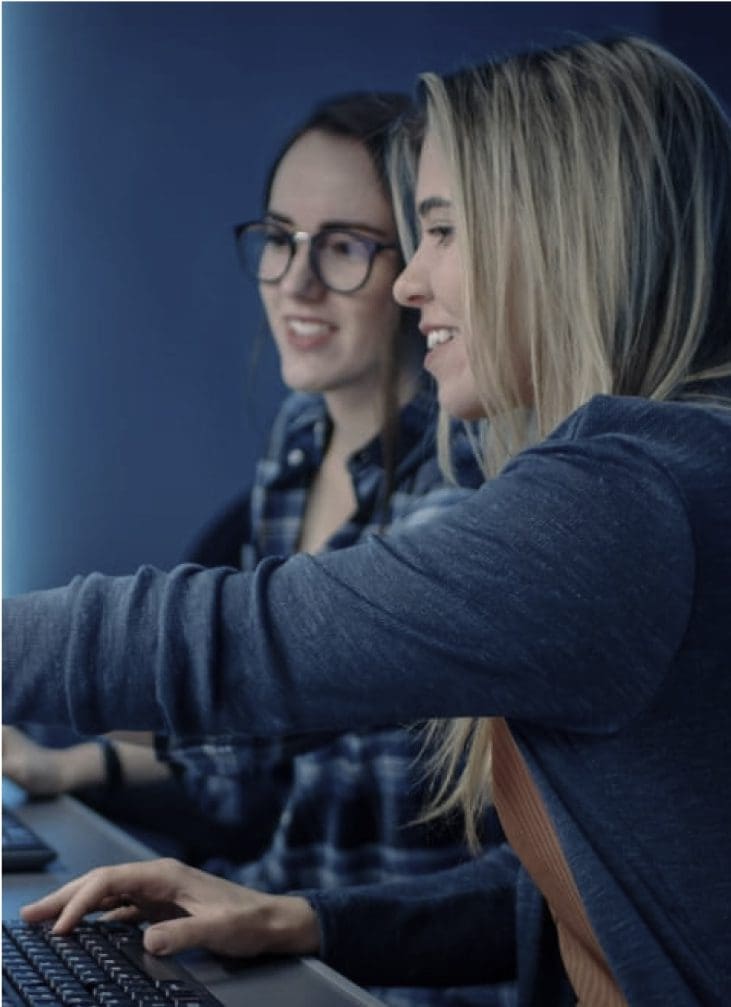Two women collaborating on a computer project.
